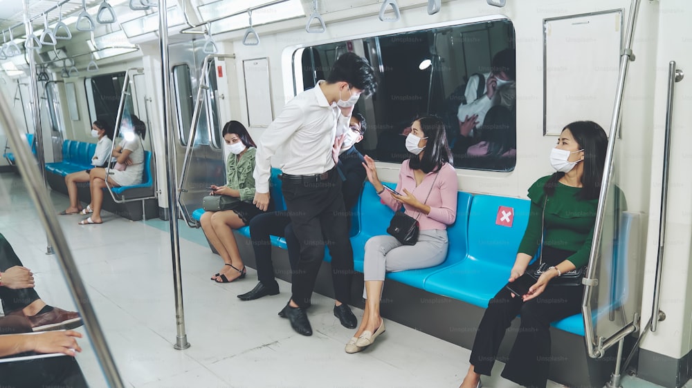 Frau hindert Mann daran, neben ihr im Zug zu sitzen, um sich sozial zu distanzieren. Coronavirus-Krankheit oder COVID-19-Pandemie-Ausbruch und städtisches Lebensstilproblem im Berufsverkehrskonzept.