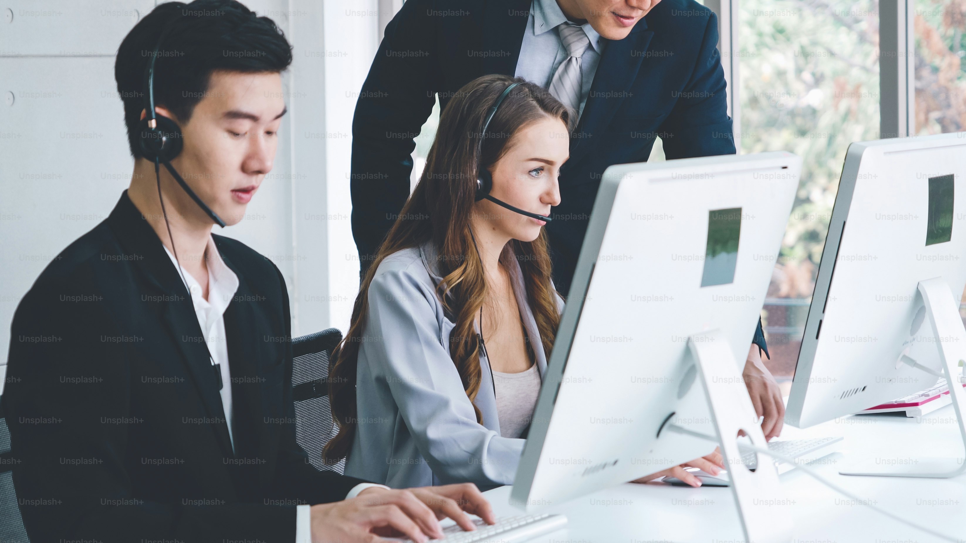 Business people wearing headset working in office to support remote customer or colleague. Call center, telemarketing, customer support agent provide service on telephone video conference call.