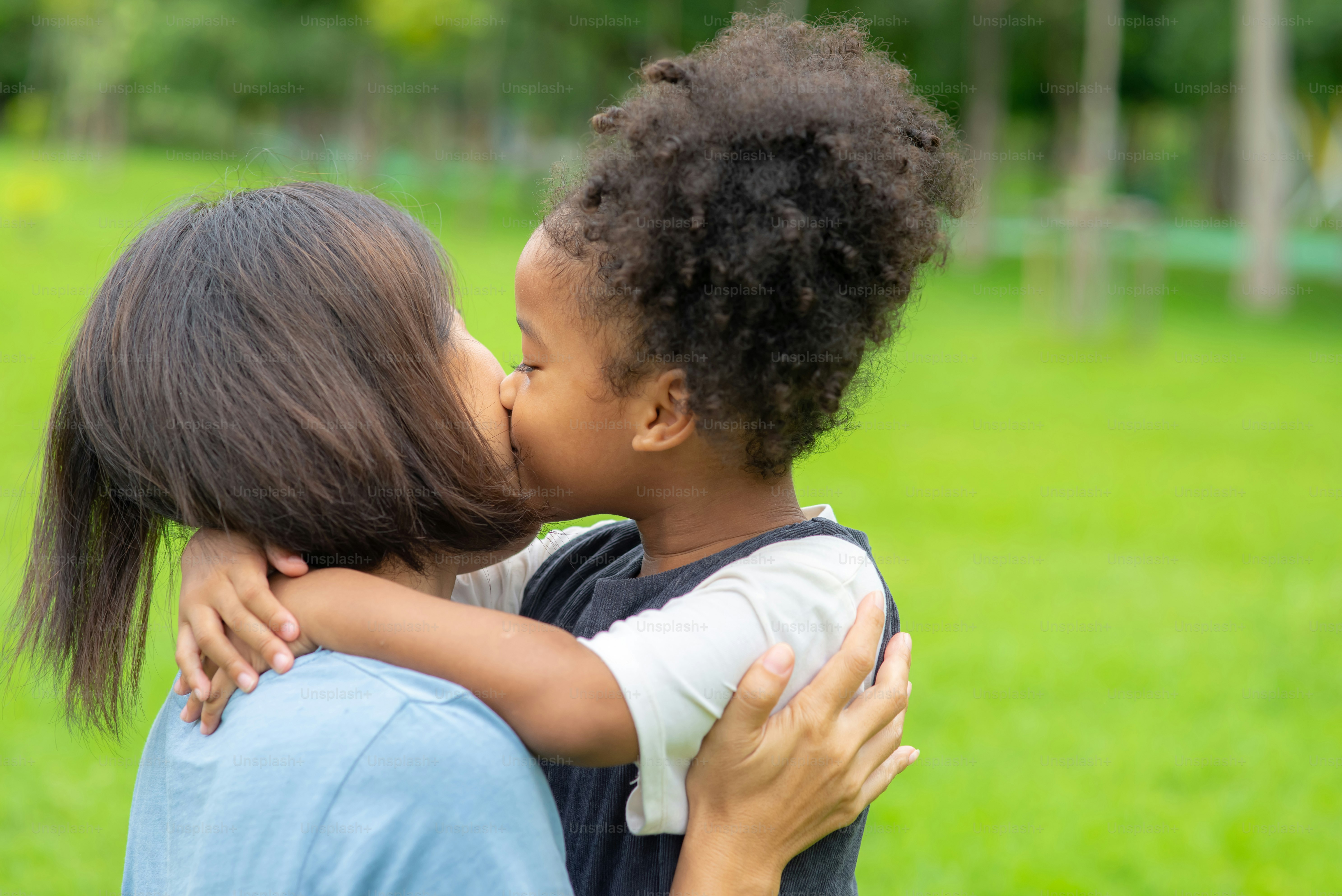 Foto Hija mestiza besando a su madre en el parque – Gente Imagen en ...