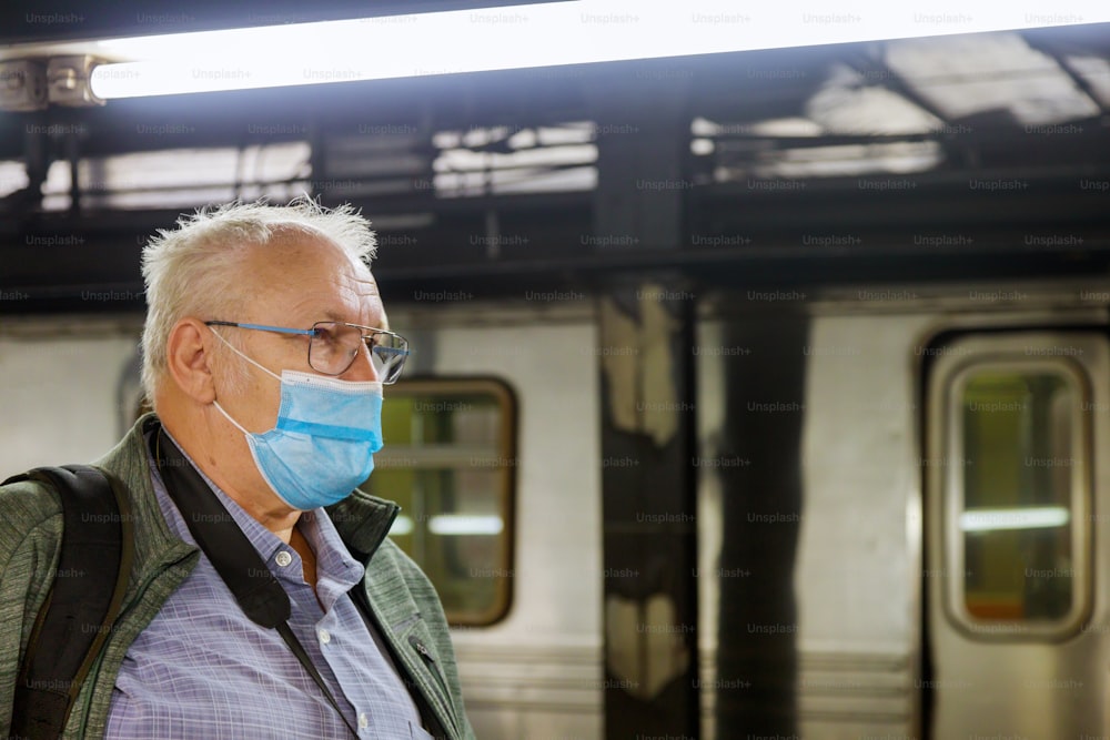 Uomo in maschera usa e getta per il viso nella stazione della metropolitana Covid-19 pandemia epidemica di coronavirus sulla metropolitana del treno treno di messa a fuoco morbida dell'assistenza sanitaria maschile