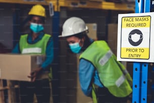 Caution sign in factory warning to industry labor worker to prevent Covid-19 Coronavirus spreading during job business reopening period after epidemic crisis . Working safely concept .