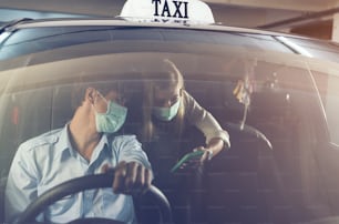 新しい標準。マスクをして車の後部座席に座っているティーンエイジャー。マスクで守られたタクシーの若い女性。交通安全。コロナウイルスパンデミック。スマートフォンのルート検索を使用する