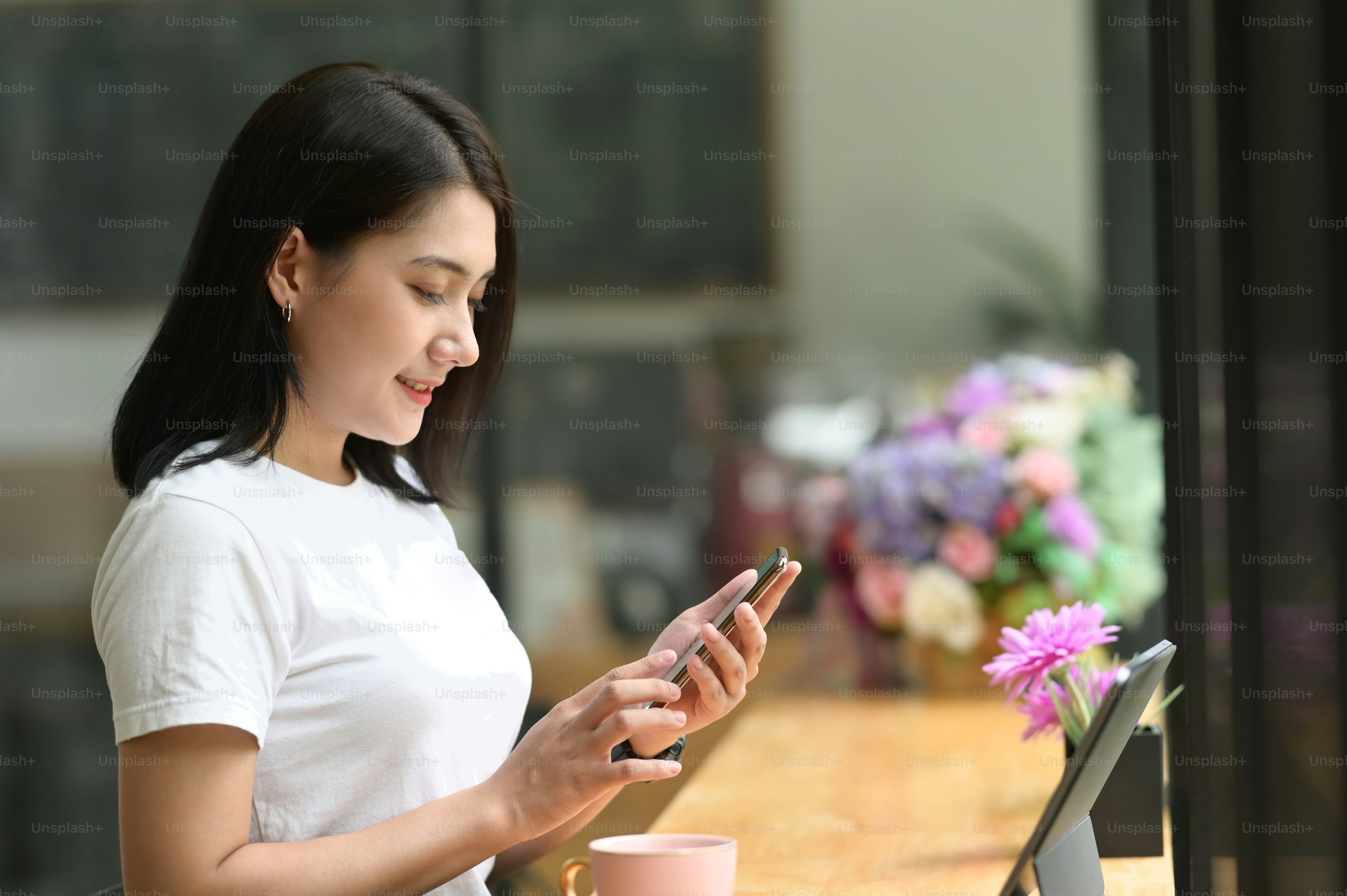 Portrait of woman smiling while   using smart phone in office.