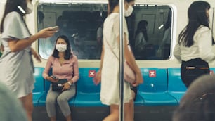 Menschenmenge mit Gesichtsmaske in einer überfüllten öffentlichen U-Bahn. Coronavirus-Krankheit oder COVID-19-Pandemie-Ausbruch und städtisches Lebensstilproblem im Berufsverkehrskonzept.