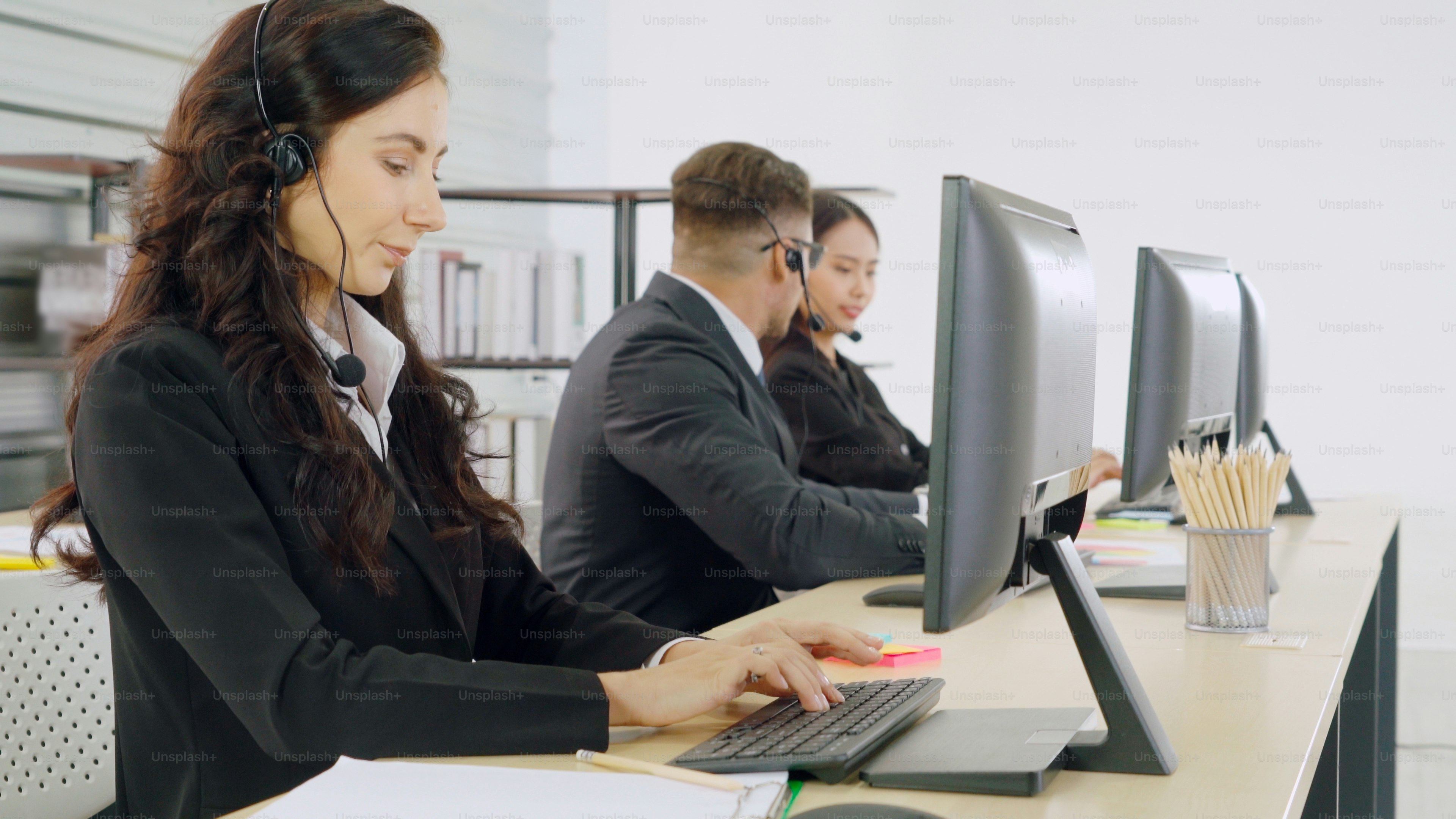 Business people wearing headset working in office to support remote customer or colleague. Call center, telemarketing, customer support agent provide service on telephone video conference call.
