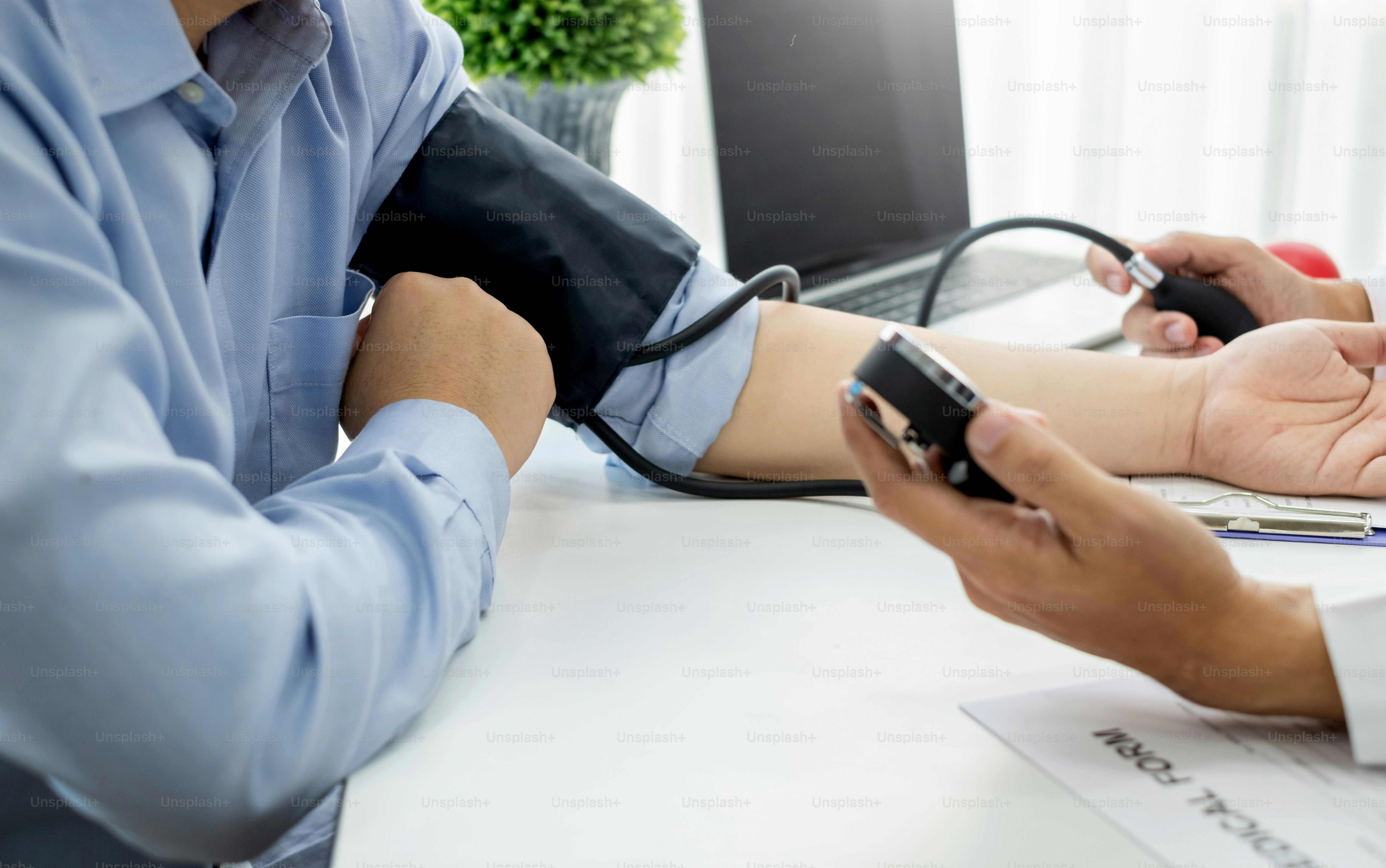 Doctor man is checking the blood pressure of the patient.