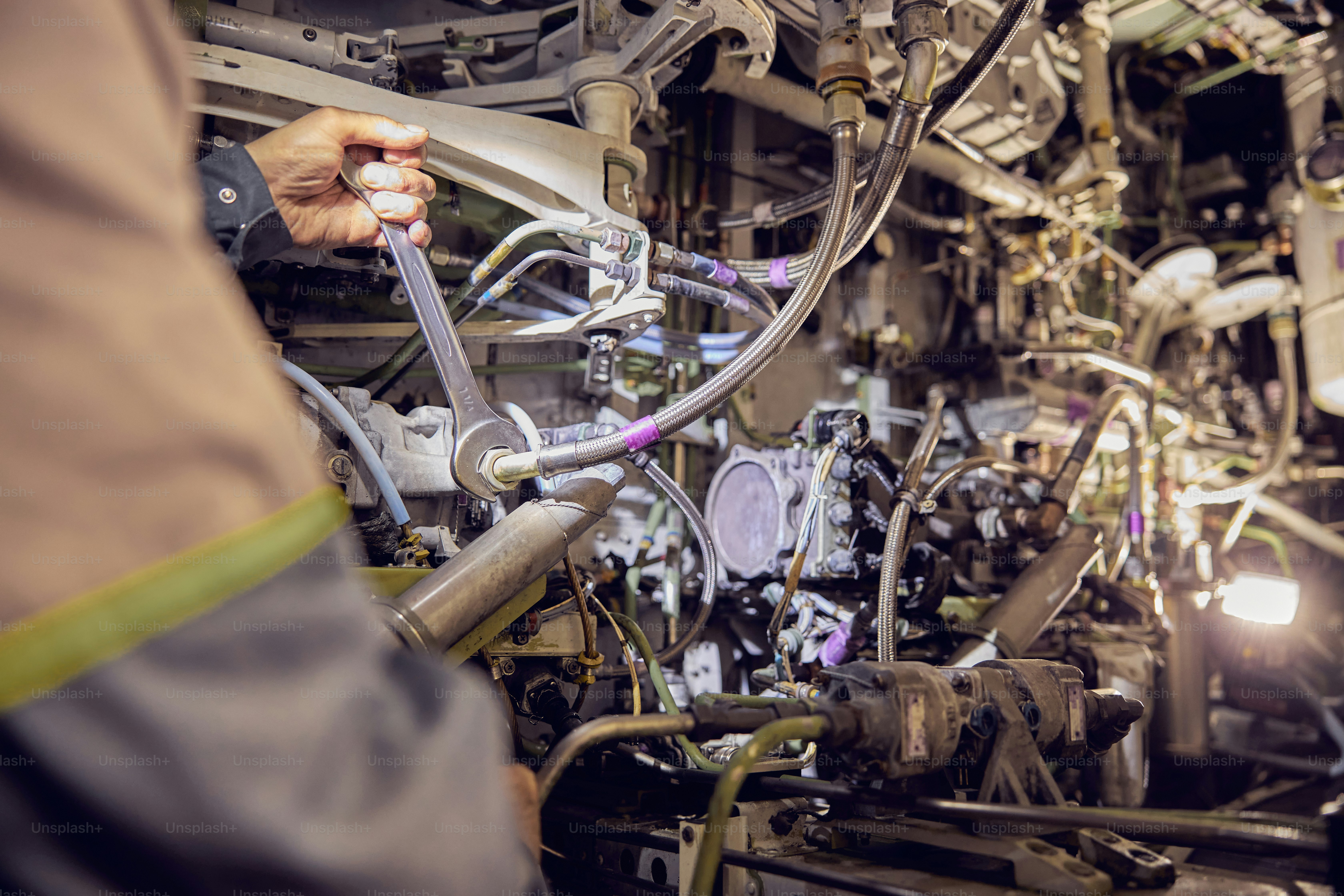 Cropped head portrait of aircraft engineer inside of airplane repairing and maintaining commercial airplane