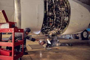 Ritratto dell'ingegnere aeronautico nell'hangar che ripara e mantiene il motore a reazione dell'aeroplano