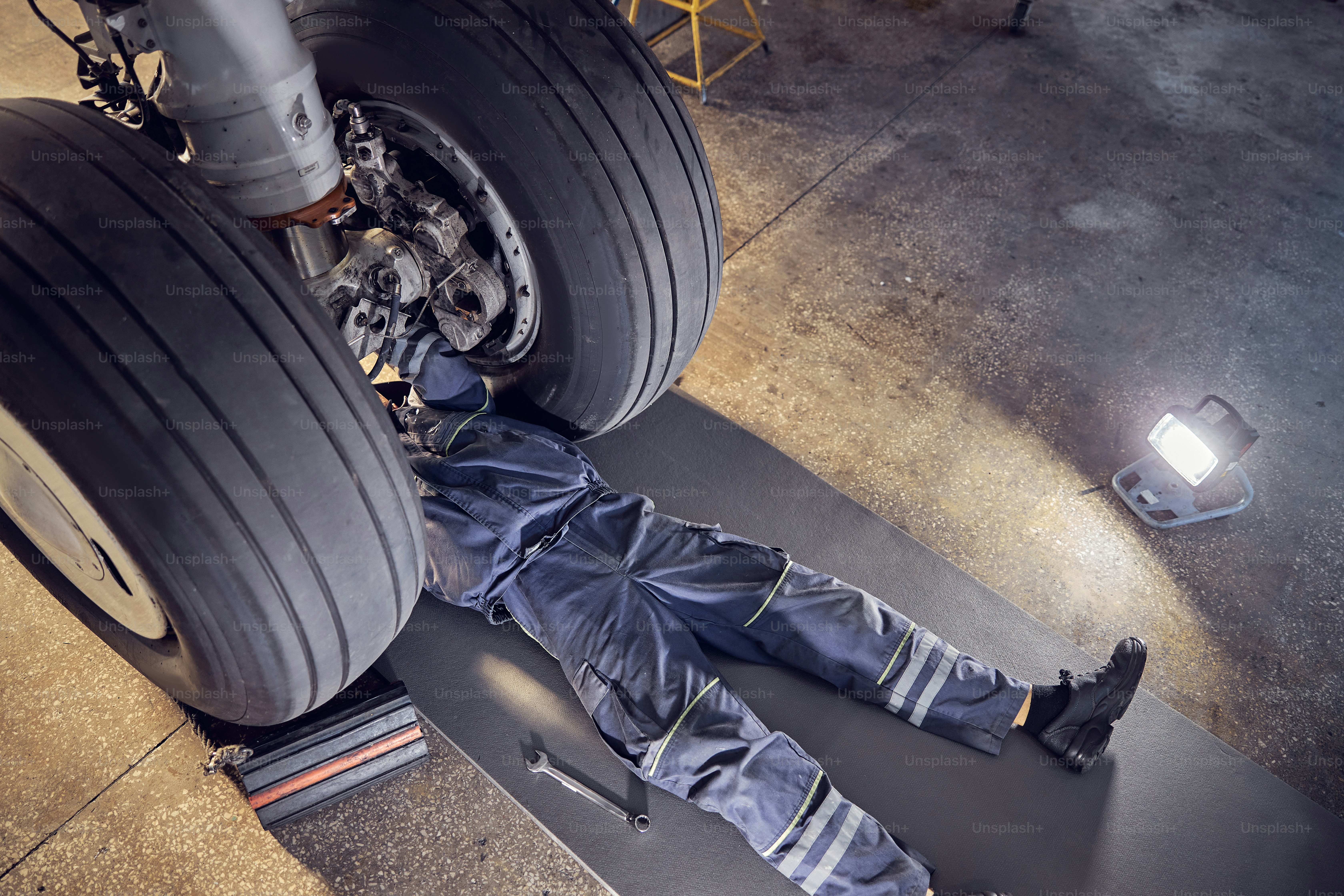 Side view portrait of airplane maintenance mechanic inspecting on ...