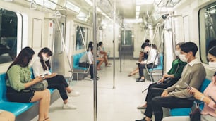 Crowd of people wearing face mask on a crowded public subway train travel . Coronavirus disease or COVID 19 pandemic outbreak and urban lifestyle problem in rush hour concept .