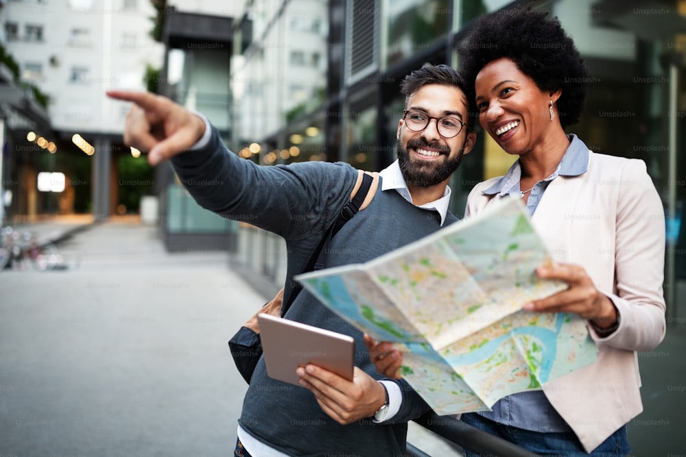 Lost couple in the city holding a map. Travel, tourism, people concept