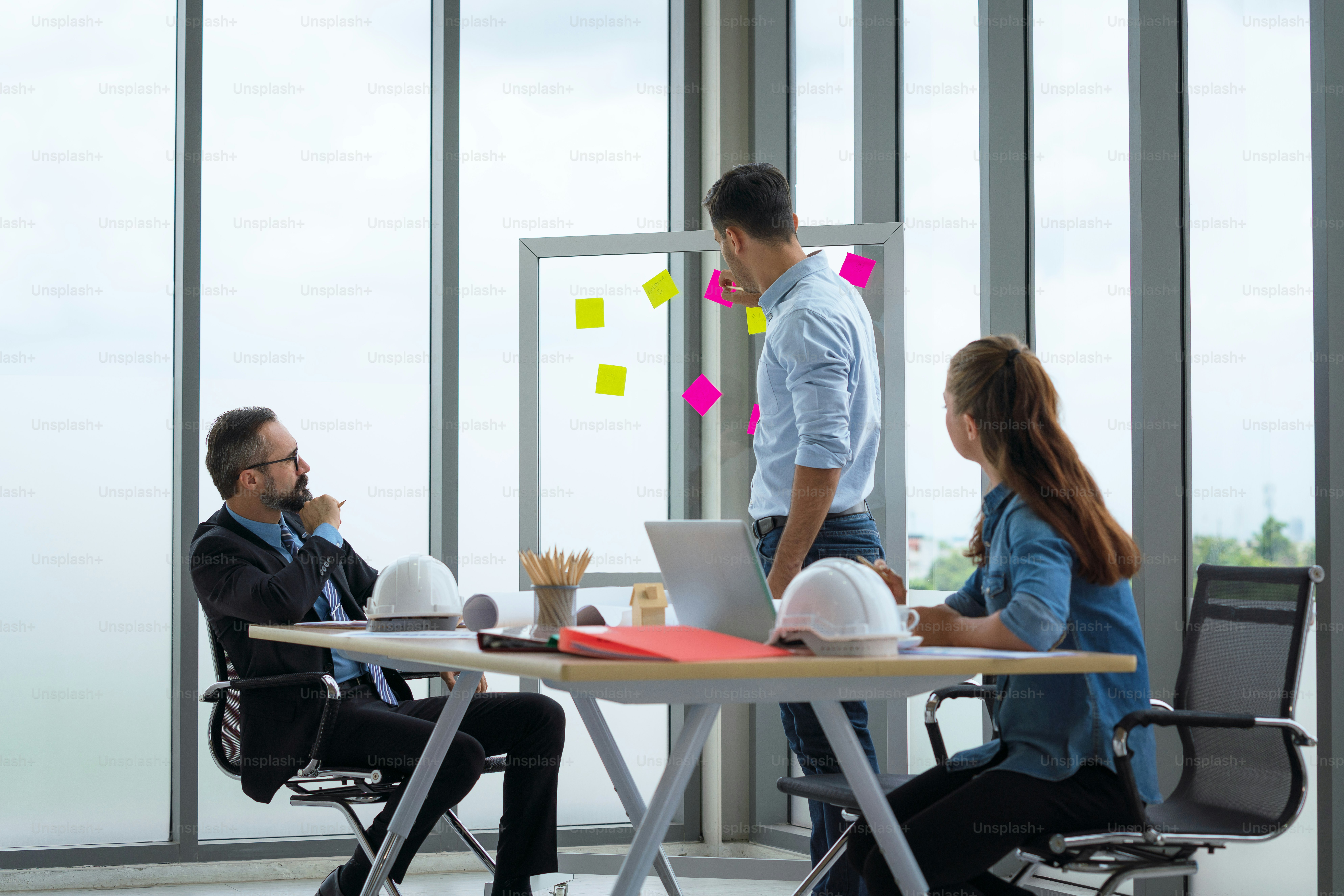 Team of multiethnic architects working on construction plans in meeting room. Engineers discussing on project in office.