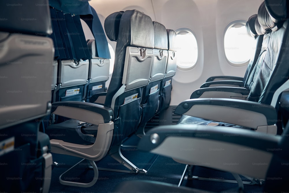 Side view image of empty airplane seats and window without the passenger on chairs in economy class