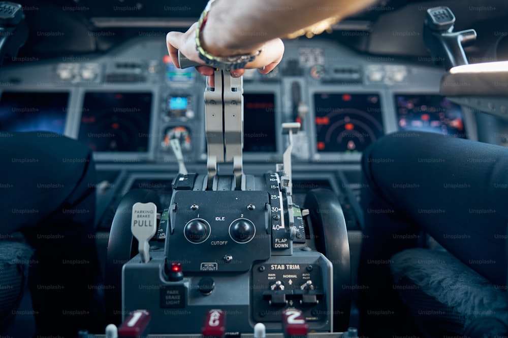 パイロットアームのクローズアップポートレートは、離陸と着陸を飛ぶために飛行機を制御しています