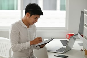 デジタルタブレットで自宅で仕事をするアジアのデザイナー。