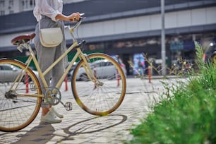 Cropped head portrait of beautiful woman with retro city bicycle walking on the famous historical place