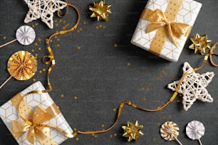 고급 선물, 황금 장식, 리본, 별, 색종이가 있는 블랙 크리스마스 배경. 평평한 누워, 평면도, 오버 헤드. 크리스마스 프레임, 새해 판매 배너 디자인.