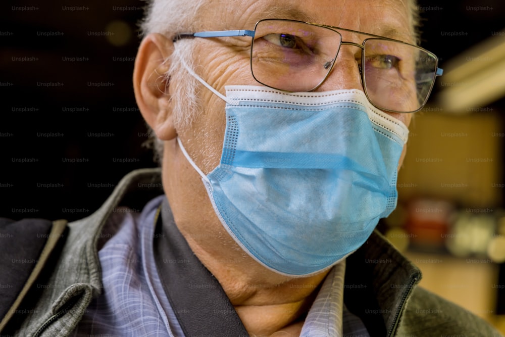 Safety in public place while epidemic mature man wearing disposable medical face mask of the subway in New York during coronavirus outbreak of covid-19.