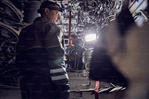 Back view portrait of aviation mechanic working on the modernization and renovation process in the aircraft repair hall