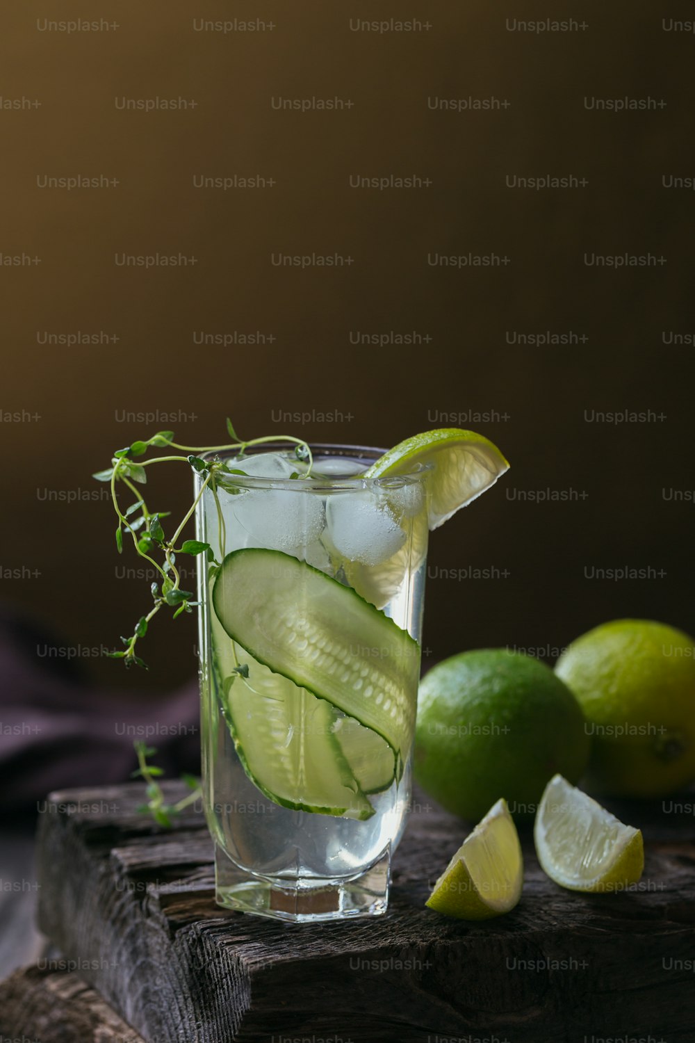 Glas Gurkencocktail oder Mocktail, erfrischendes Sommergetränk mit Crushed Ice und Mineralwasser auf Holzhintergrund.