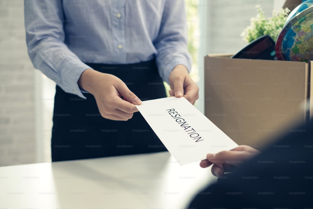 Mujer de negocios que envía una carta de renuncia al ejecutivo o gerente. Concepto de extinción de la relación laboral y renuncia.