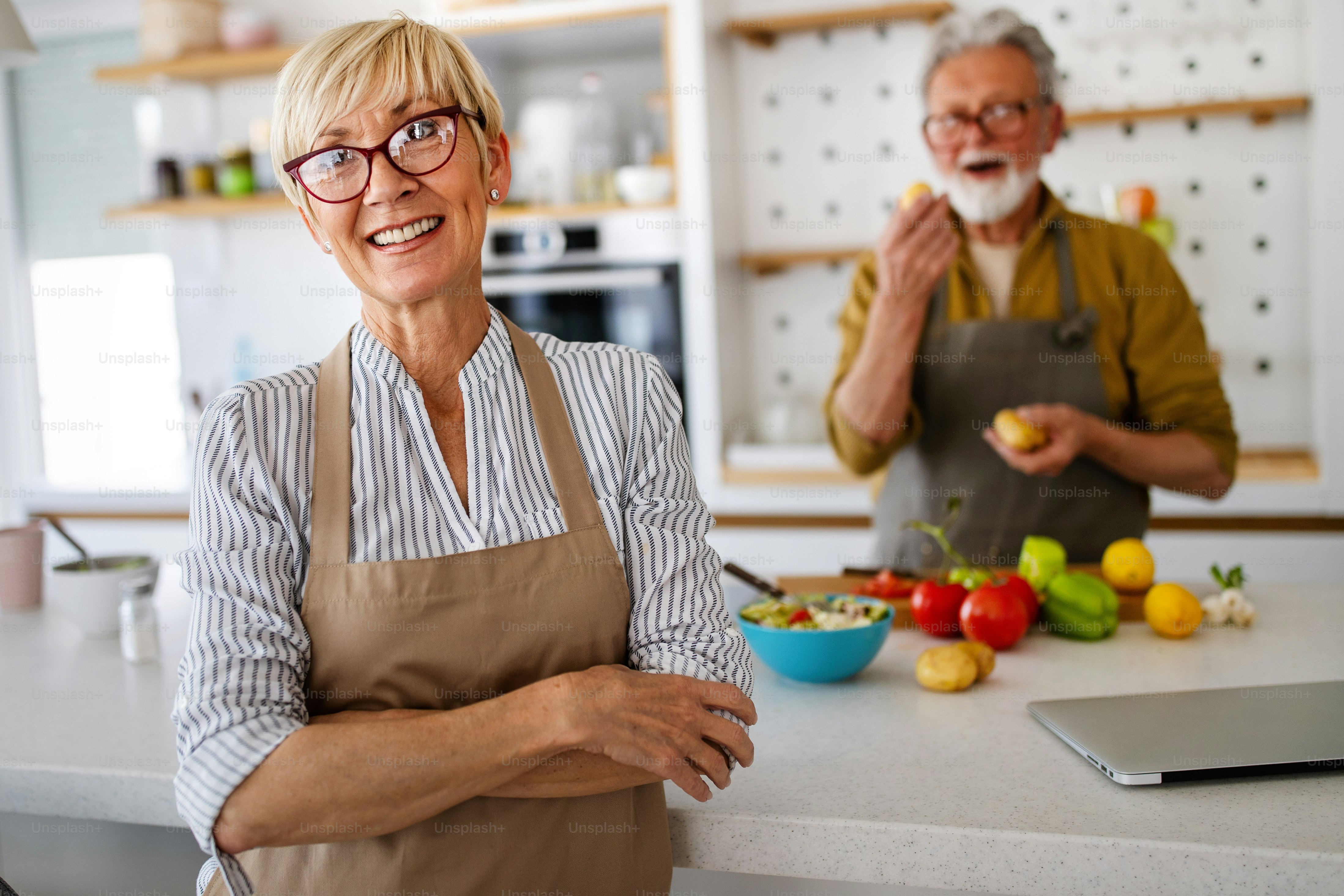 Senior couple having fun and cooking together in kitchen at home photo ...