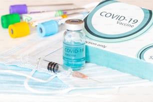 Frasco médico, viales, jeringas y mascarilla. Vacuna contra el coronavirus - Nueva vacuna contra el coronavirus Sars-Cov-2 en la mesa de laboratorio. Sesión de vacunación y mejora de la inmunidad.