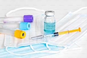 Medizinische Flasche, Fläschchen, Spritzen und Gesichtsmaske. Coronavirus-Impfstoff - Neuer Impfstoff gegen Coronavirus Sars-Cov-2 auf dem Labortisch. Impfsitzung und Verbesserung der Immunität.