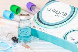 医療用ボトル、バイアル、注射器、フェイスマスク。コロナウイルスワクチン - 実験台に置かれたコロナウイルスSars-Cov-2に対する新しいワクチン。ワクチン接種セッションと免疫力の向上。