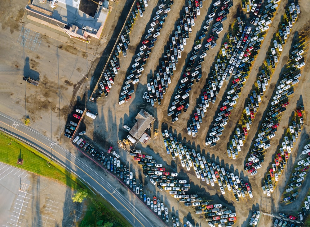 Vista aérea de muitos lotes de leilão de carros usados estacionados distribuídos em um estacionamento.