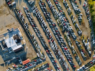 Vue aérienne supérieure de la vente aux enchères de voitures de nombreux lots de voitures d’occasion garées dans un parking.