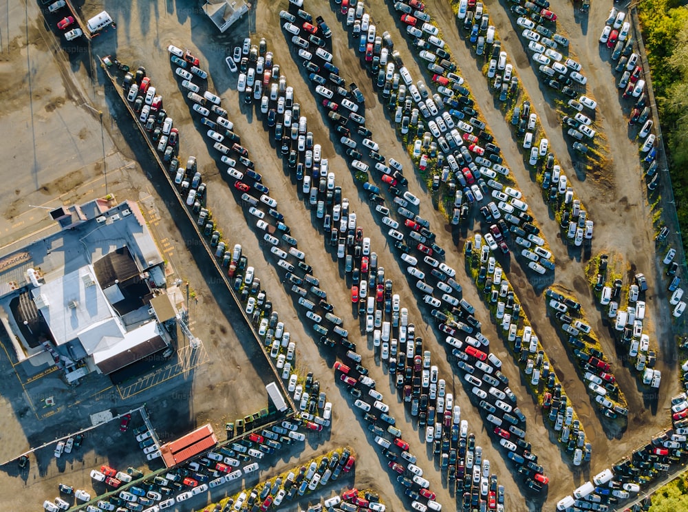 Vista aérea superior do leilão de automóveis muitos carros usados estacionados distribuídos em um estacionamento.