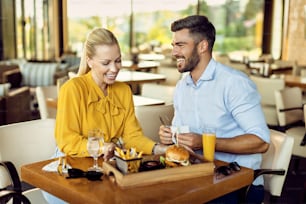 Heureux couple d’adultes en train de déjeuner ensemble dans un restaurant.