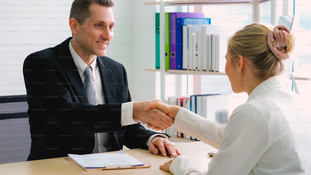 Job seeker and manager handshake in job interview meeting at corporate office. The young interviewee seeking for a professional career job opportunity . Human resources and recruitment concept.