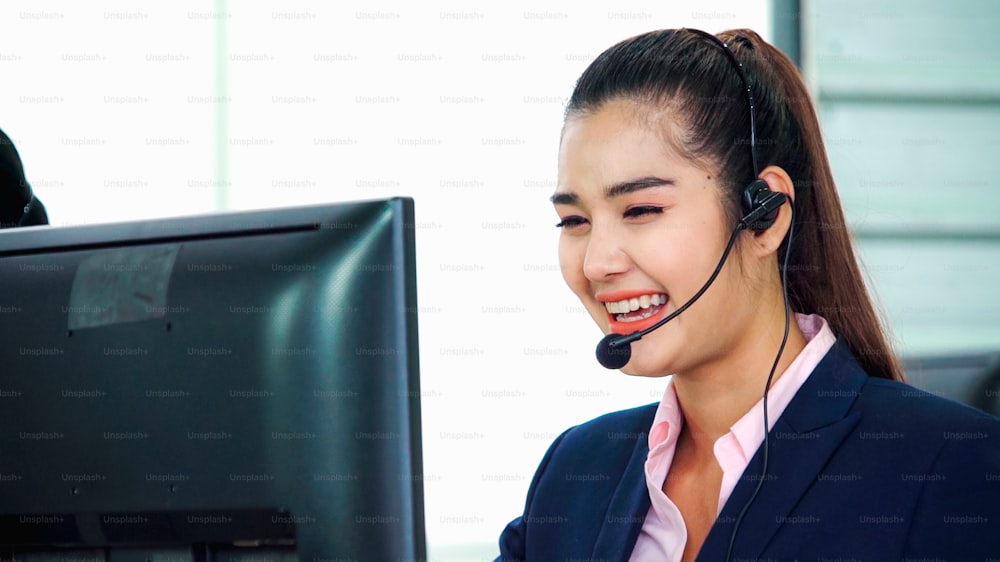 Business people wearing headset working in office to support remote customer or colleague. Call center, telemarketing, customer support agent provide service on telephone video conference call.