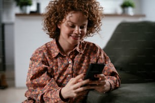 Young woman using the phone. Beautiful woman enjoying at home.