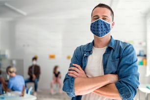 Front view portrait of young man with face mask waiting, coronavirus, covid-19 and vaccination concept.