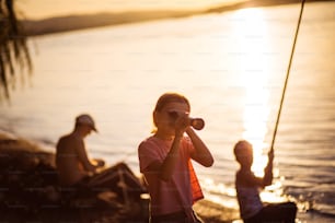 Little girl looking through telescope outside