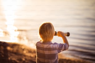 Little boy looking through telescope outside