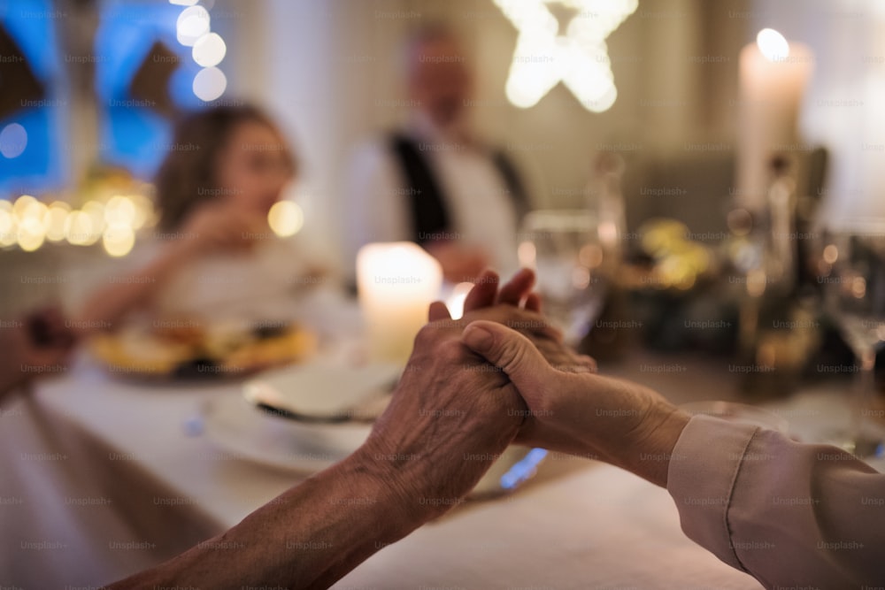 Close-up of hands holding together at the table at Christmas, detail.