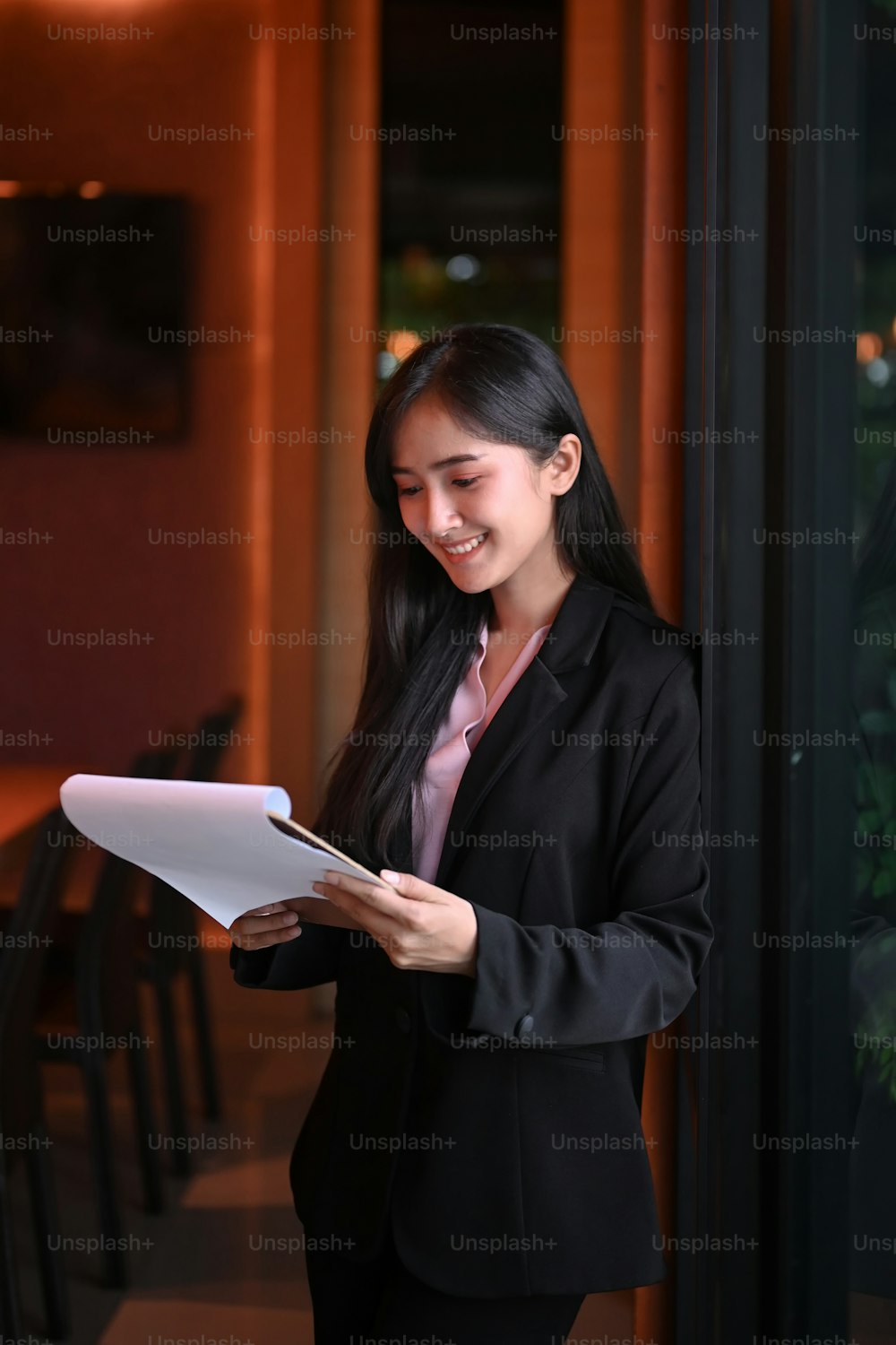 Portrait of young businesswoman reading document in office.