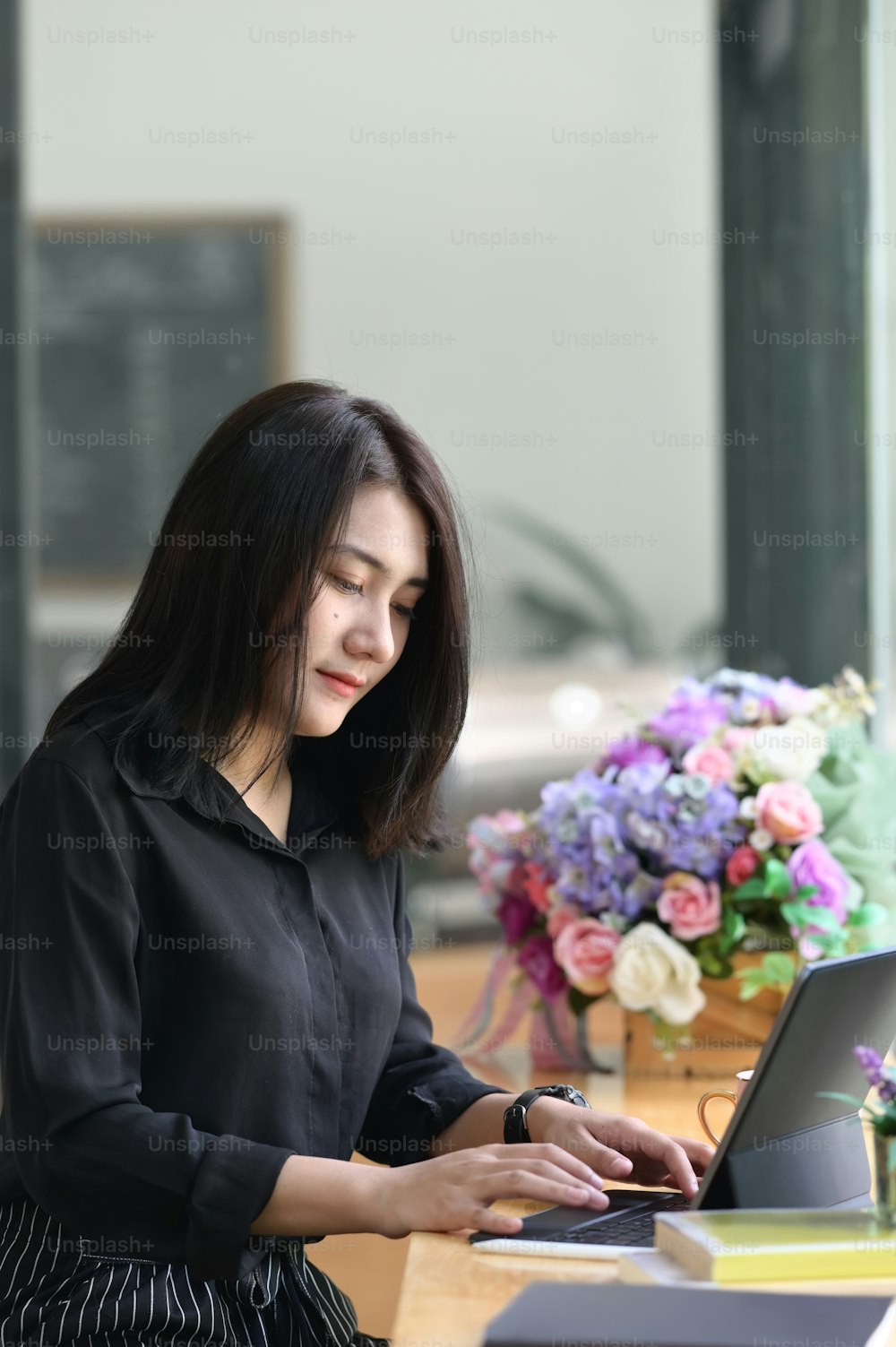 Portrait of female office worker concentrating on her work in modern office.