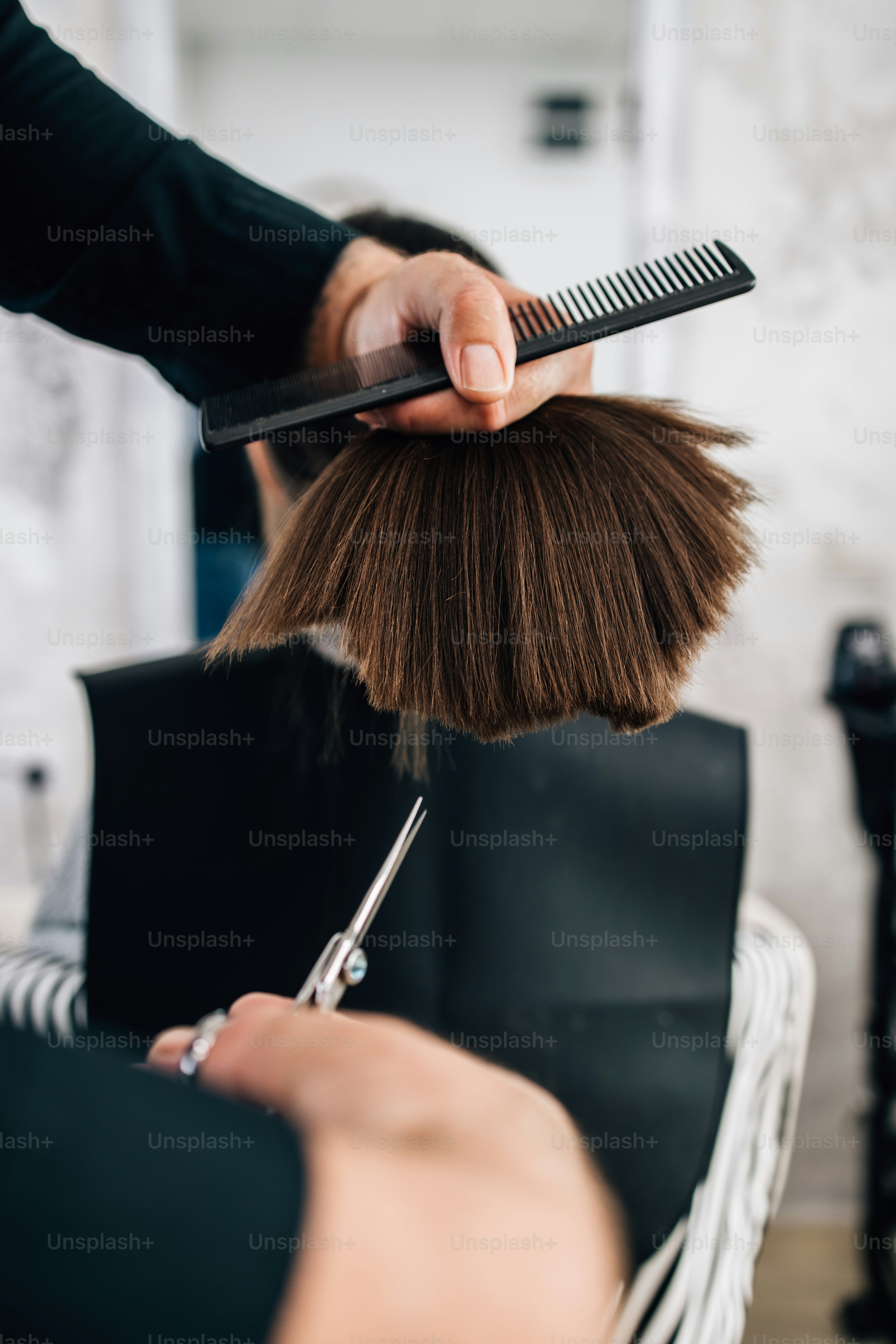 Giovane ragazza al trattamento dell'acconciatura mentre il parrucchiere professionista le lava delicatamente i capelli.