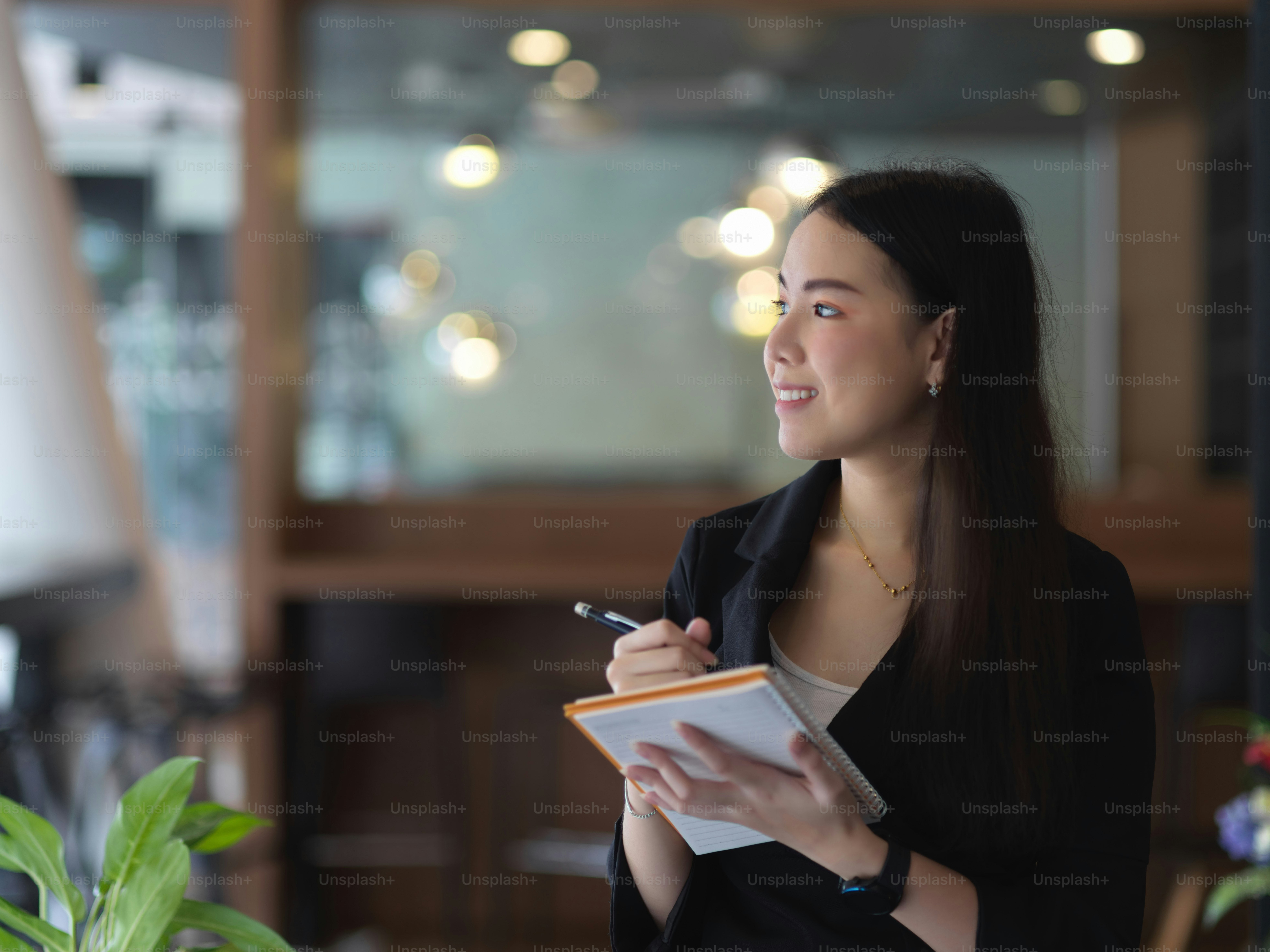 Portrait of businesswoman working with schedule book while standing in meeting room