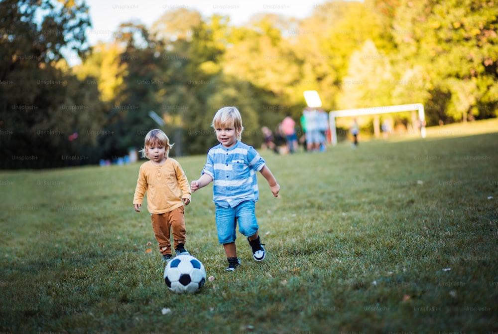 Dois meninos jogando futebol.