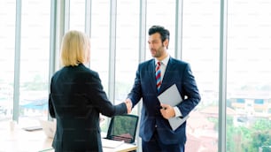 Business people handshake in corporate office showing professional agreement on a financial deal contract.