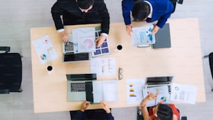 Business people group meeting shot from top view in office . Profession businesswomen, businessmen and office workers working in team conference with project planning document on meeting table .