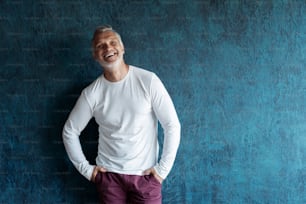 Casual Grey-haired Mature handsome man portrait over dark blue wall background