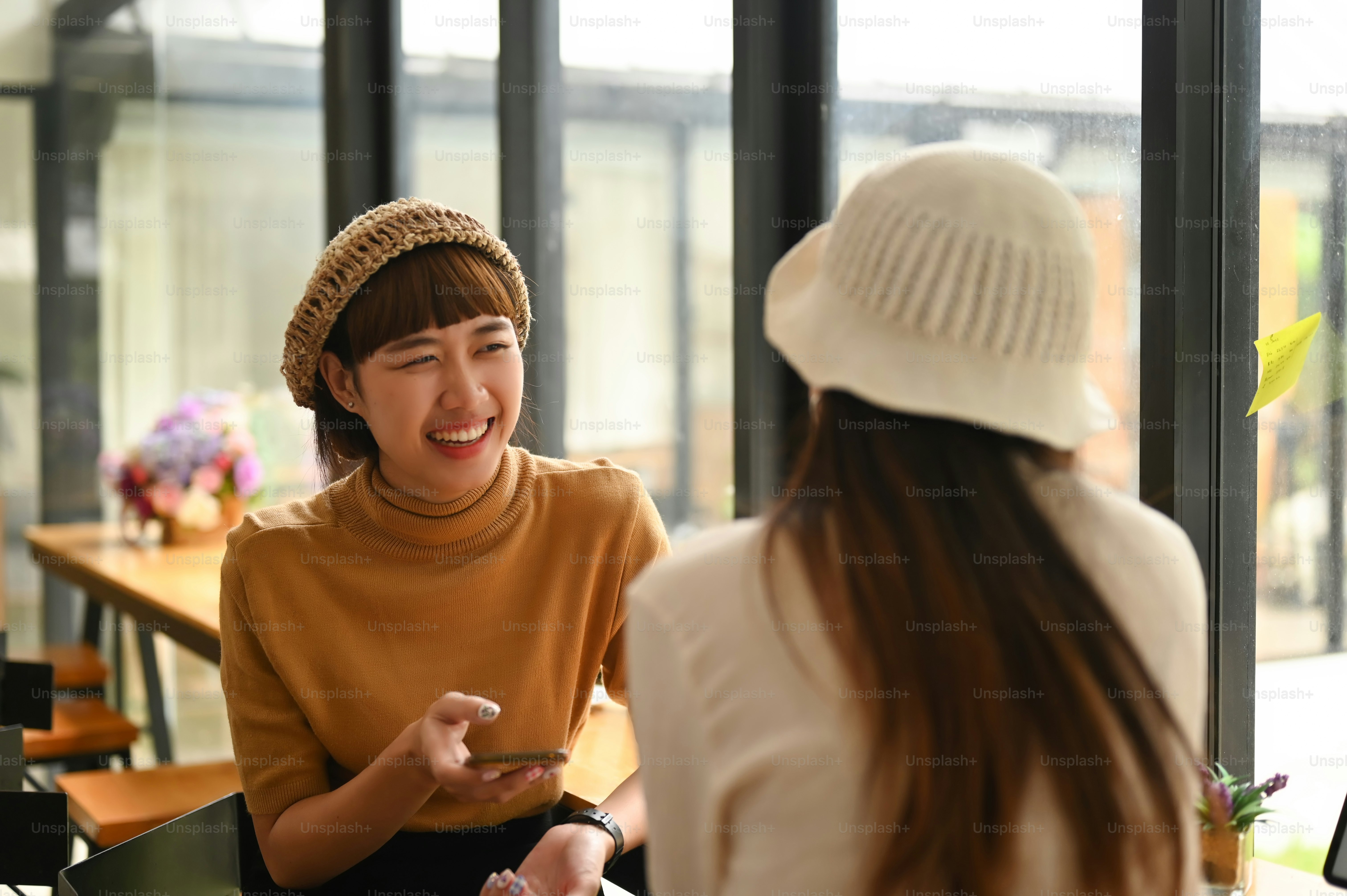 Two happy businesswomen sitting and talking for new project planning in office.
