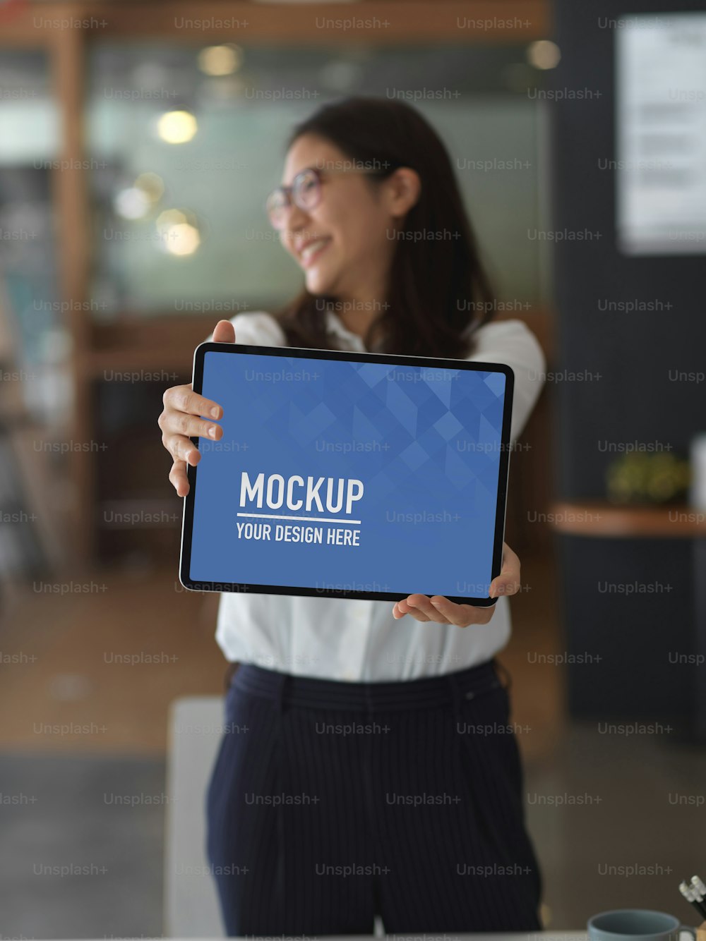 Young asian businesswoman showing mock up blank screen tablet while standing in the office room , clipping path